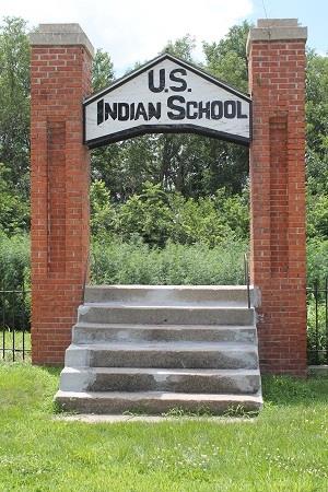 Steps and columns with US Indian School sign, no building behind it